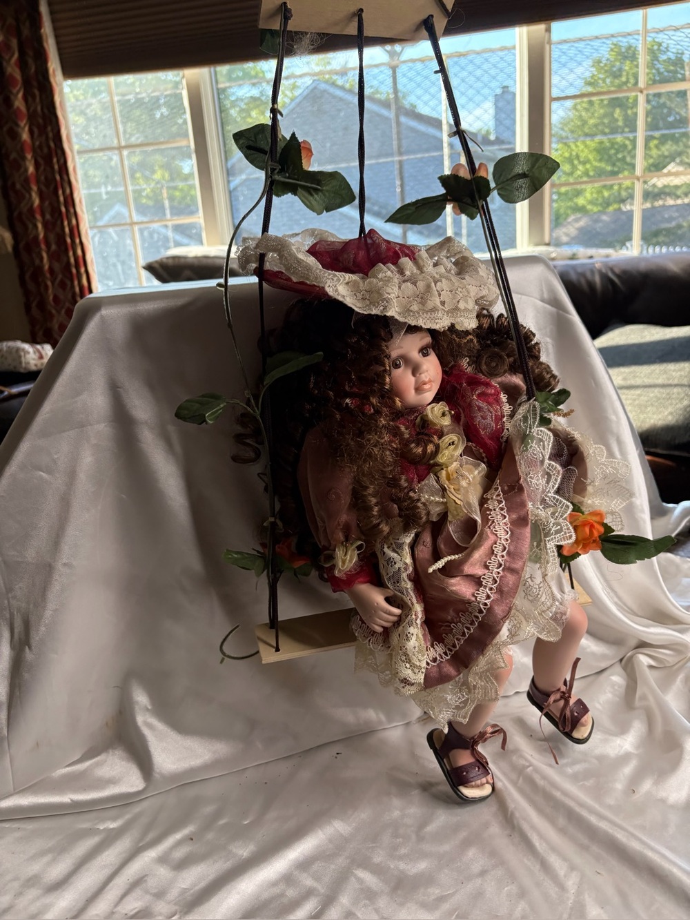 Cathay Collection porcelain doll on a wooden swing set